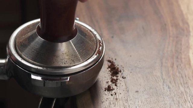 Closeup tamping fresh ground coffee
