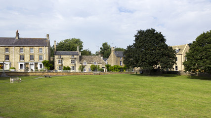 Cotswold homes alongside the green in Shipton-under-Wychwood, Oxfordshire, UK