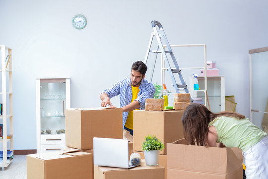 Young family unpacking at new house with boxes