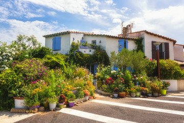 Fototapeta na wymiar Saintes-Maries-de-la-Mer, small mediterranean town, cozy house decorated with different flowers and plants. Popular tourist destination in Camargue, Provence, France