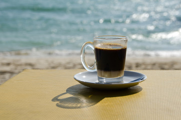 Close up Coffee cup on table and view of tropical beach.