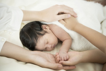 Newborn baby and parents putting their hands together with stack of hands  . Newborn kind and Love symbol