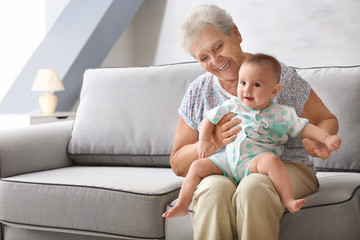 Senior woman playing with her little grandchild at home - obrazy, fototapety, plakaty