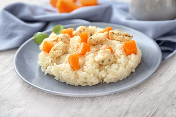 Plate with delicious pumpkin risotto on wooden table