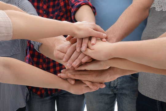 Young people putting hands together as symbol of unity, closeup