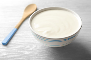 Fototapeta na wymiar Tasty yogurt in dish on wooden table