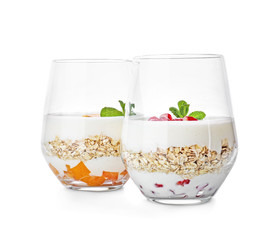 Yogurt with oat flakes in glasses on white background