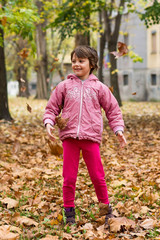 A girl in nature is playing with leaves