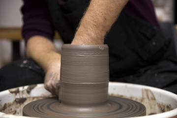 Artist makes clay pottery on a spin wheel