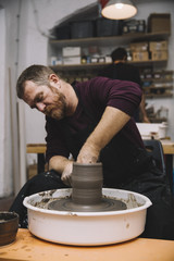 Artist makes clay pottery on a spin wheel