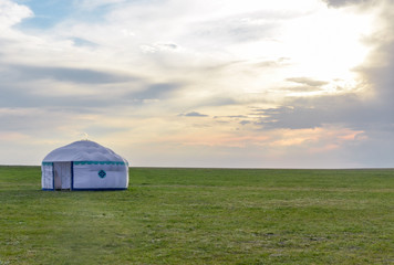 lone Kalmyk yurt in green spring steppe at sunset Manych-Gudilo, Kalmykia