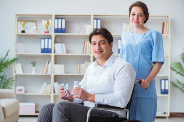 Obraz premium Disabled patient on wheelchair visiting doctor for regular check