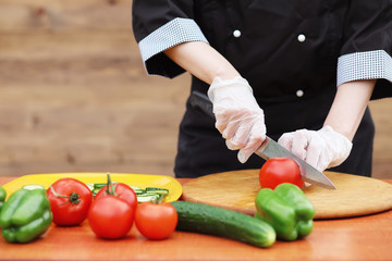 The cook cuts fresh farm vegetables