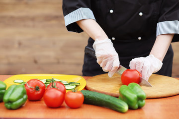 The cook cuts fresh farm vegetables