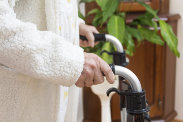 6.	Grandma in a white bathrobe. The wrinkled hands of a very old woman hold the handles of the...