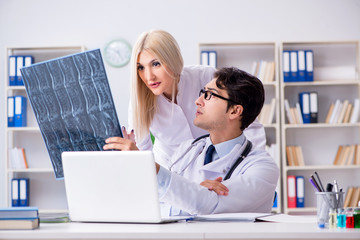 Two doctors examining x-ray images of patient for diagnosis