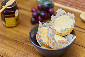 sponge cakes,cup cakes in a bowl with jam on wooden background 