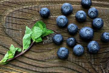 Blueberries with mint on antique wooden table