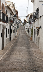 One of the streets of the beautiful old town Altea, located in the Costa Blanca of Spain. White houses with flowers