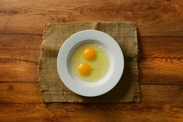 Fototapeta na wymiar two egg yolks in the white plate