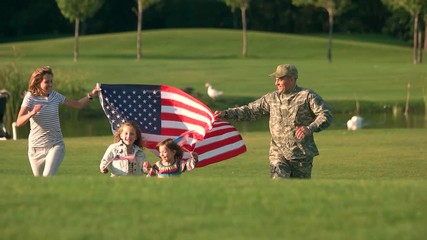 Wife and husband holding one big usa background. Patriotic family running together. - Powered by Adobe