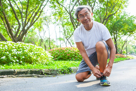 Sport Old Man Or Senior Runner Tying Shoelaces Getting Ready Jogging In Park