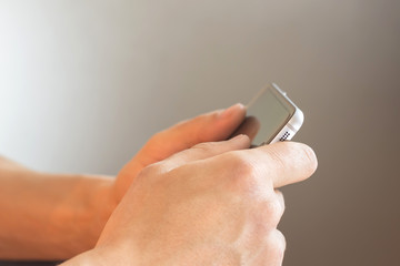 Close up men's hands holding cell telephone. copy space. watching video, games on mobile phone