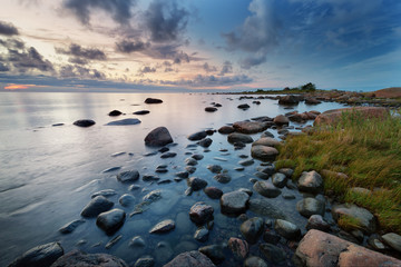 Fototapeta na wymiar Rocky shores at the sea in sunset light. Lahemaa natural park coastal landscape with beautiful sky
