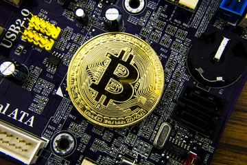 Cryptocurrency Bitcoin On The Motherboard. Gold Coin. Virtual Currency.