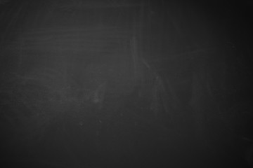 Black background showing matte rough wood blackboard texture with erased chalk.