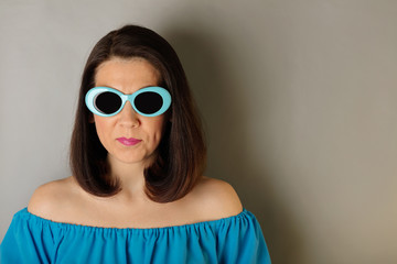 Woman in azure dress and sunglasses.