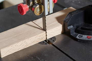 DIY concept. Woodworking and crafts tools. Sawing Hardwood workpiece on the bandsaw