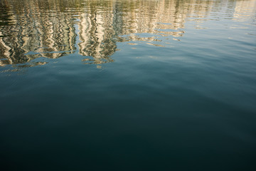 Skyscrapers reflecting in sea water; Shenzhen, China;