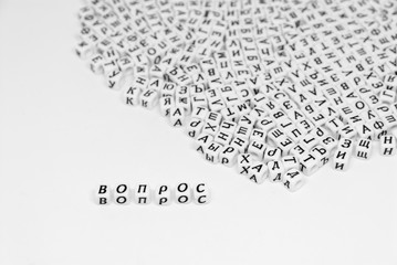 scattered cyrillic letters on white background and word question written in cyrillic black and white photo