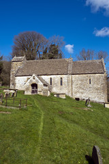 Spring sunshine on the picturesque old church at Duntisbourne Rouse in the Cotswolds, Gloucestershire, UK