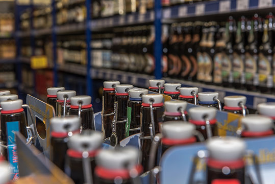 Beer bottles are stacked reusable containers are in a beverage market. Crate with full beer bottles. Focus on the bottles. Concept: drinks