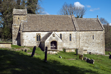 Spring sunshine on the picturesque old church at Duntisbourne Rouse in the Cotswolds, Gloucestershire, UK
