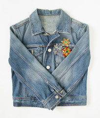 Jeans denim woman jacket with vintage brooches on white background. Fashion outfit