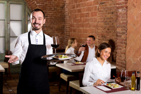 Waiter showing country restaurant to visitors