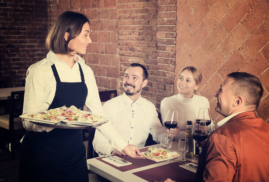 Waitress placing order in front of guests