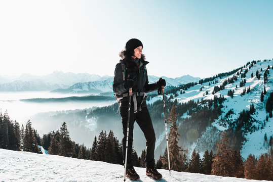 Young smiling woman hiking in snowy mountains