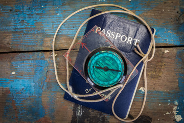 Passport and Compass on a Paint Splatterd Wooden Table