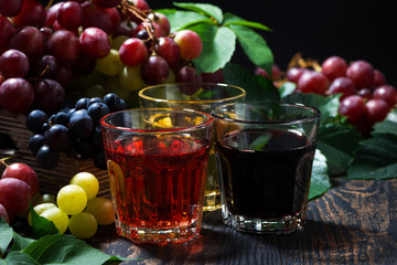 assortment of grape juice on wooden background, closeup