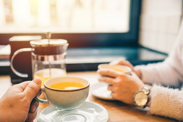 couple drink orange tea in cafe together