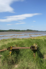 Fototapeta premium Obsolete small boats and barges were stranded on the banks of the tidal River Severn in Gloucestershire, UK to protect the river banks from erosion.