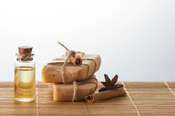 Handmade soaps, essential oils, cinnamon stick on wooden table