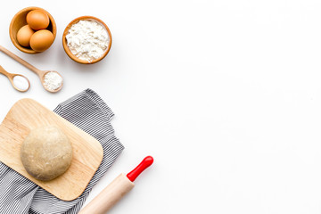 Roll out the dough. Dough ball near roller pin and other cookware on white background top view copy space