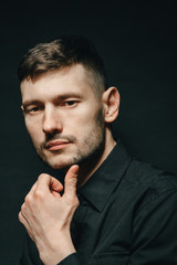 Man in headphones and black shirt on a black background