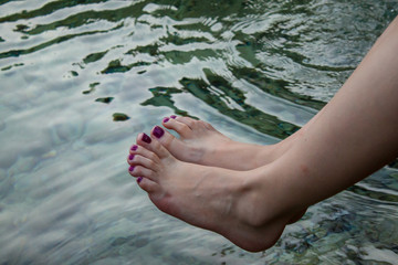 Beautiful woman legs hanging over sea water