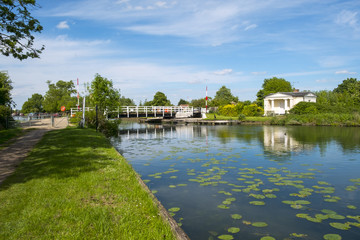 Late spring sunshine on Splatt Bridge and bridge keepers cottage on the Gloucester & Sharpness Canal at Frampton on Severn, Gloucestershire, UK